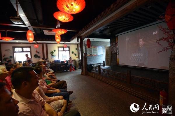 人们紧盯着屏幕观看现场直播画面。