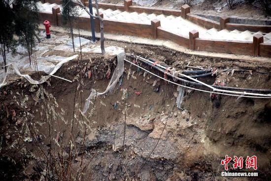 2015年12月23日,山东省济南市,记者来到坍塌现场,国土部门已经在周边搭建起围挡,安排专人值守在围挡外,阻挡游客进入。21日晚上,位于二环东路东侧的燕翅山发生塌陷,出现一处深约10米的深坑。塌方发生后,不远处的公厕墙体开裂出不少裂痕,宽度在一两厘米左右,不少居民担心山体的整体安全状况。“这周边居住的人家很密集,还有一个小学,万一出现更大范围的塌方,后果不堪设想。”居民们希望有关部门对坍塌的具体原因能够做出详细的说明。