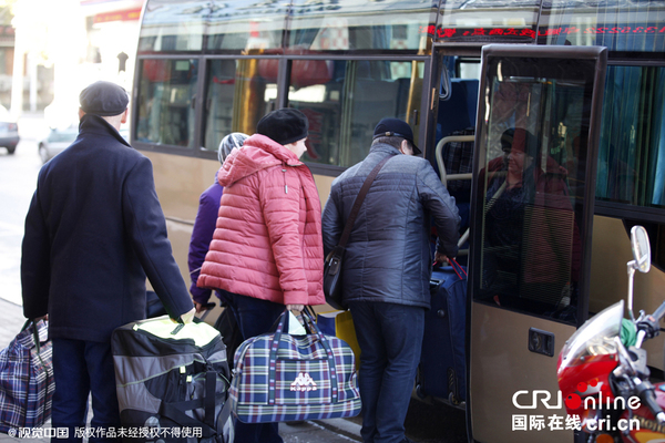2015年10月24日,黑龙江黑河,俄罗斯大妈组团乘坐两辆中巴赴黑河扫货购物。 俄罗斯游客拎着或拖拉着一大包或几大包购买的商品准备乘车离开。图片来源:cfp